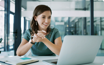 image of a women happily looking at her laptop image of a women happily looking at her laptop
