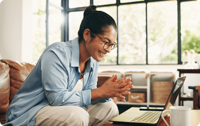 image of woman smiling at her laptop image of woman smiling at her laptop