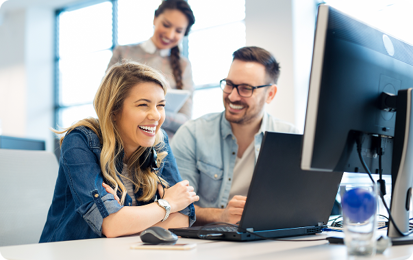 picture of coworkers laughing at desk